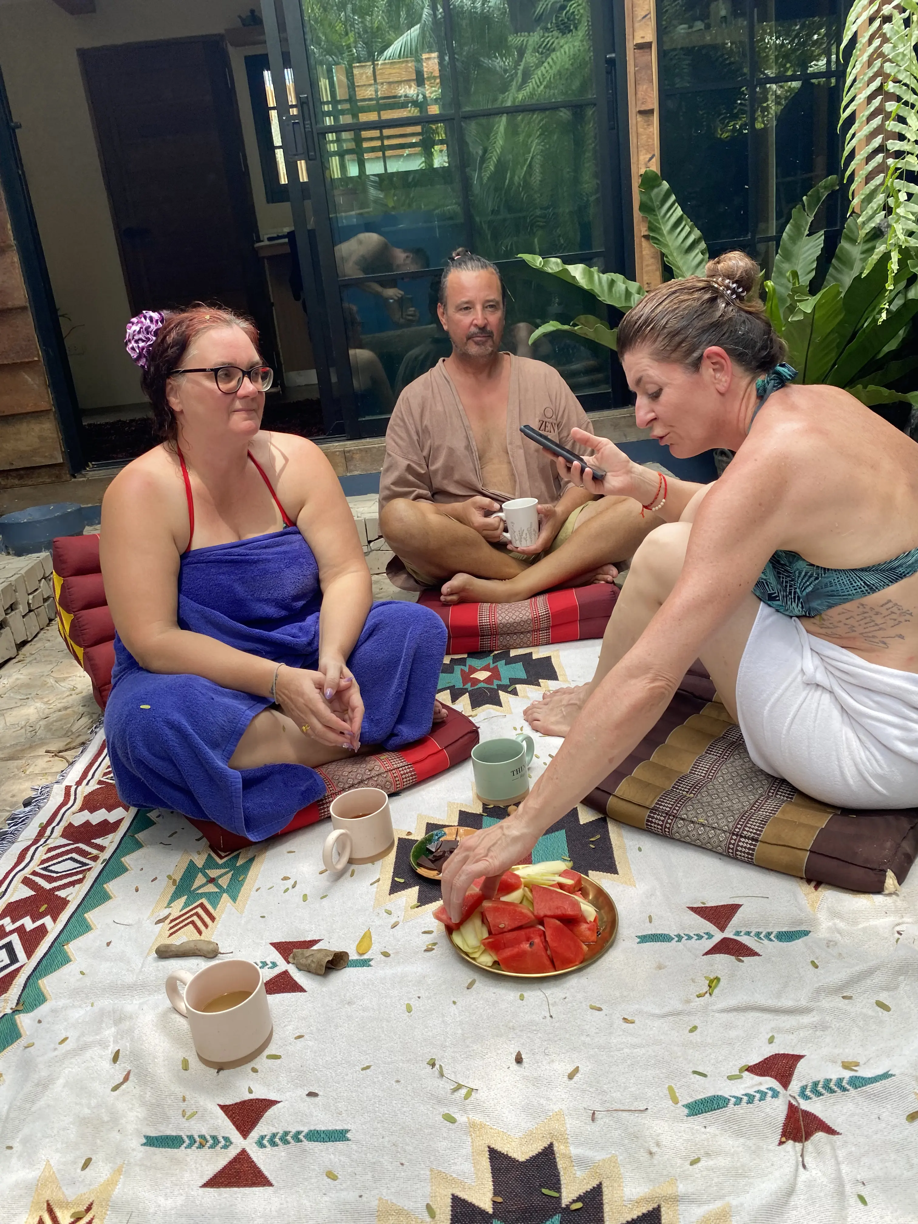 Guests relaxing with tea and fruit in the Zen Pod courtyard